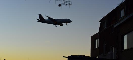 Avion qui survole des maisons la nuit tombée