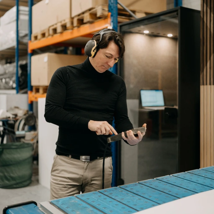 Un homme dans un atelier avec casque regarde un appareil numérique
