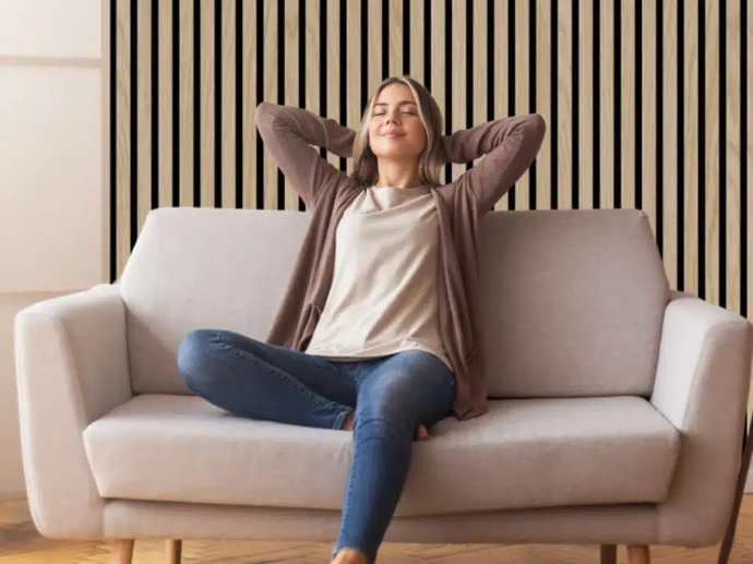 Une dame est étendue dans un divan dans un salon moderne décoré de panneaux en lambris
