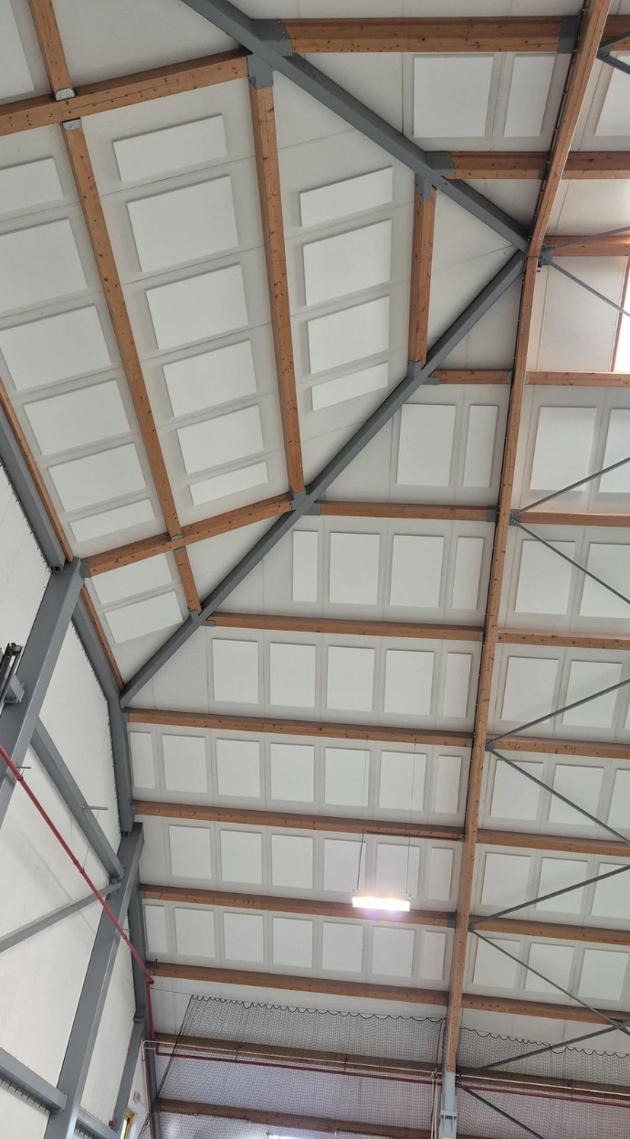 Panneaux en mousse de mélamine installés au plafond d'un grand espace sportif